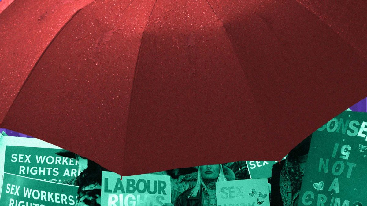 Red umbrella with protest signs for decriminalizing sex work underneath
