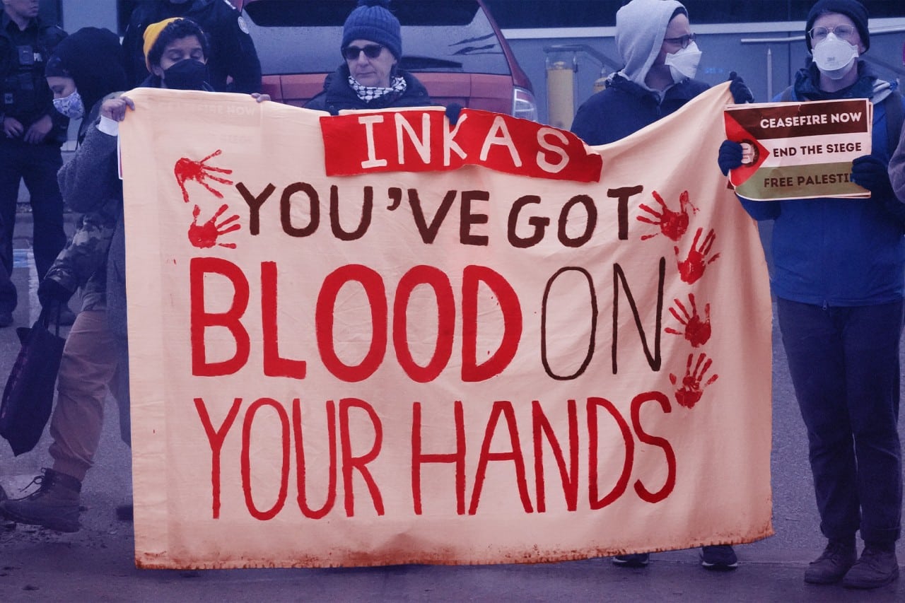 Photo shows a protester holding a sign that says "Inkas: You've got blood on your hands."